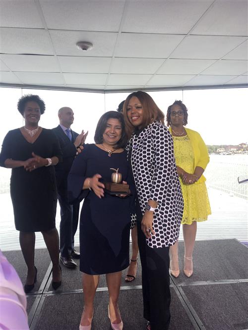 2 ladies standing from stage with a group of people standing behind them 
